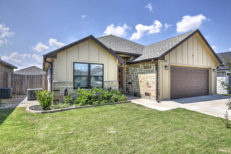 Home exterior with a green lawn and covered entry