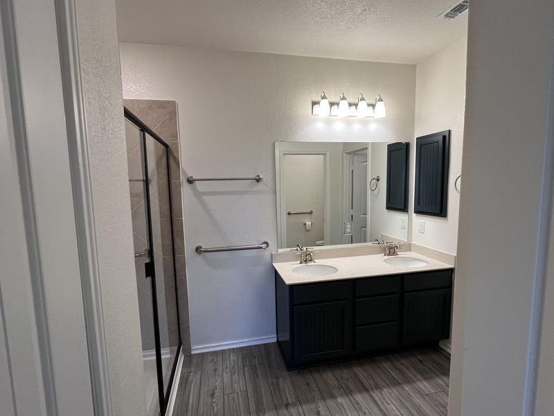 Bathroom with dark cabinetry and a double vanity