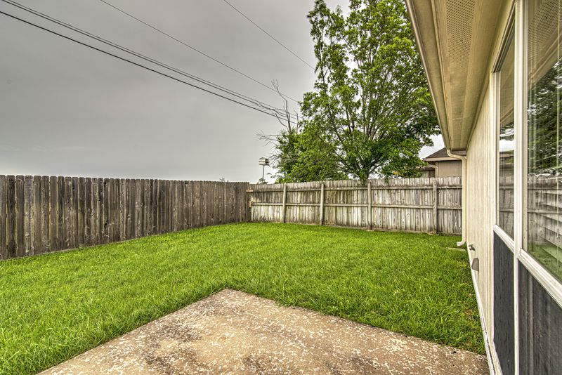 Fenced backyard with a patio and lawn